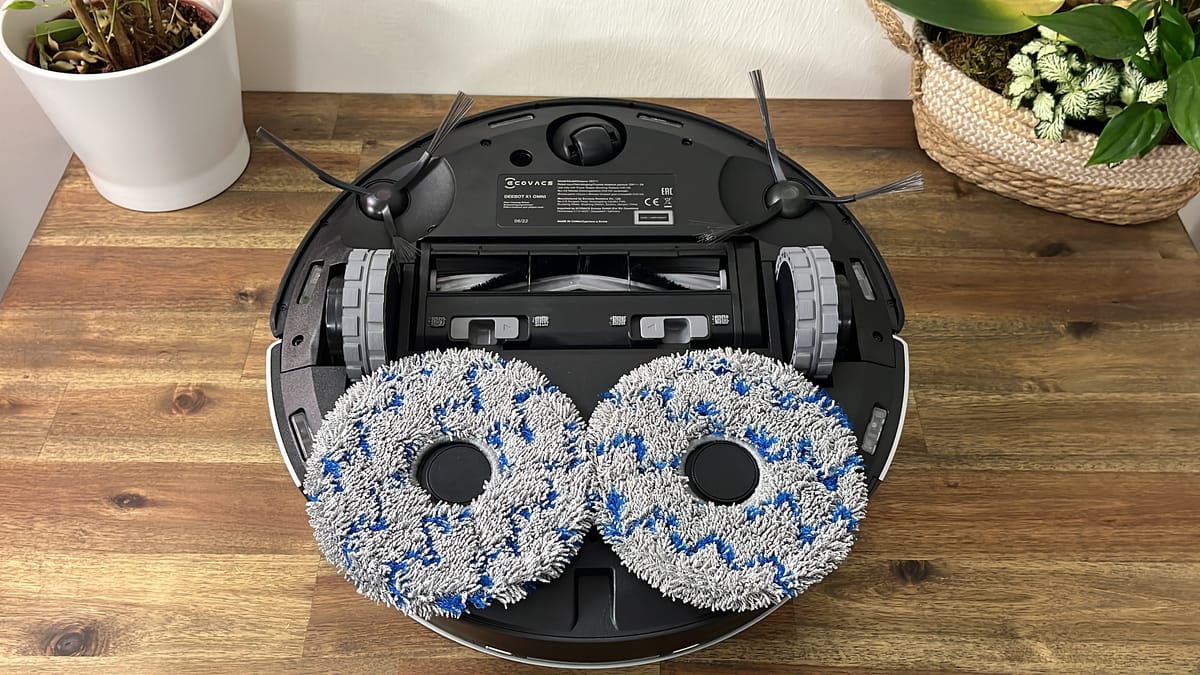 Ein Ecovacs Saugroboter von unten mit sichtabren rotierendene Wischmopps