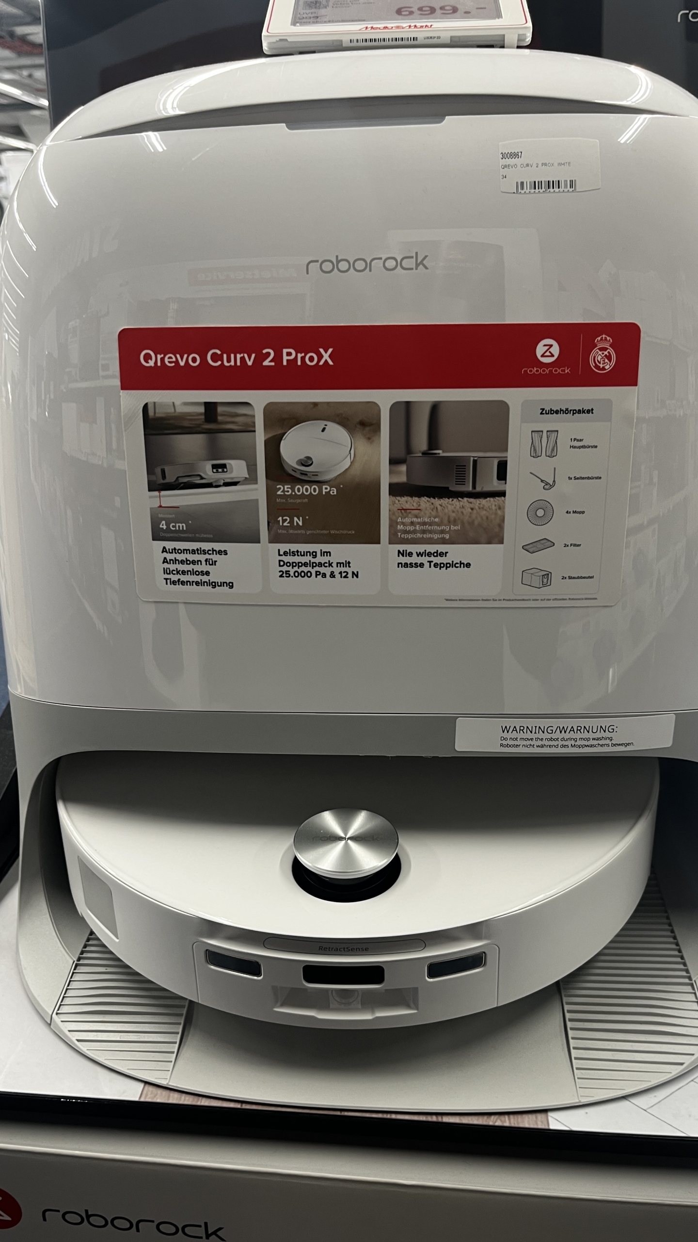 Roborock Qrevo Curv 2 ProX vor seiner Reinigungsstation auf einer Produktpräsentation