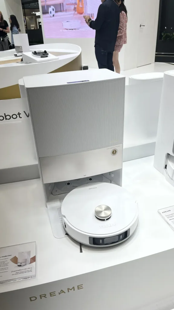 DreameBot L20 Ultra vor seiner automatischen Reinigungsstation, eigene Messeaufnahme