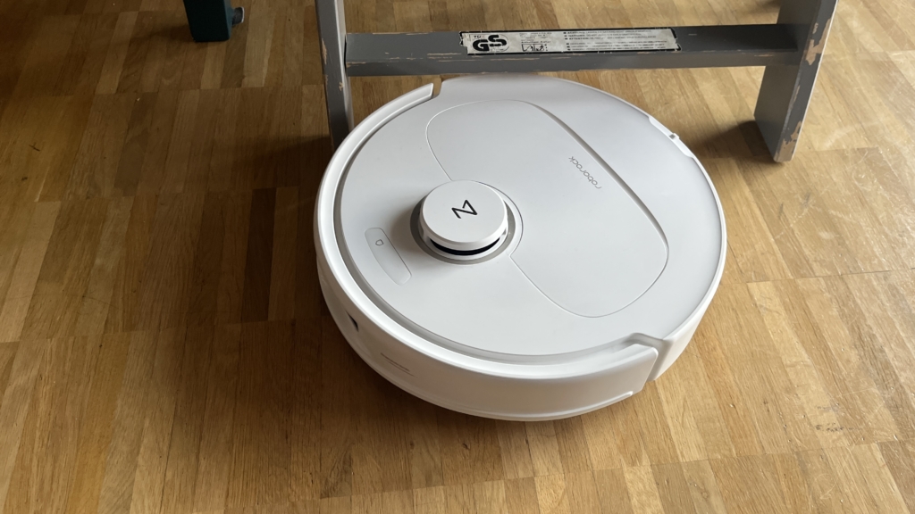 Roborock Qrevo Pro fährt unter einem niedrigen Möbelstück